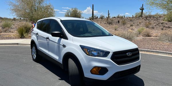 A freshly detailed white SUV gleaming under a clear blue sky